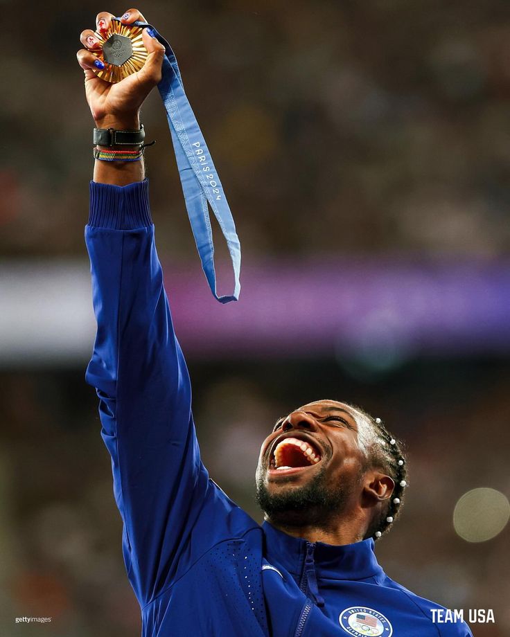 a man holding up a medal in the air