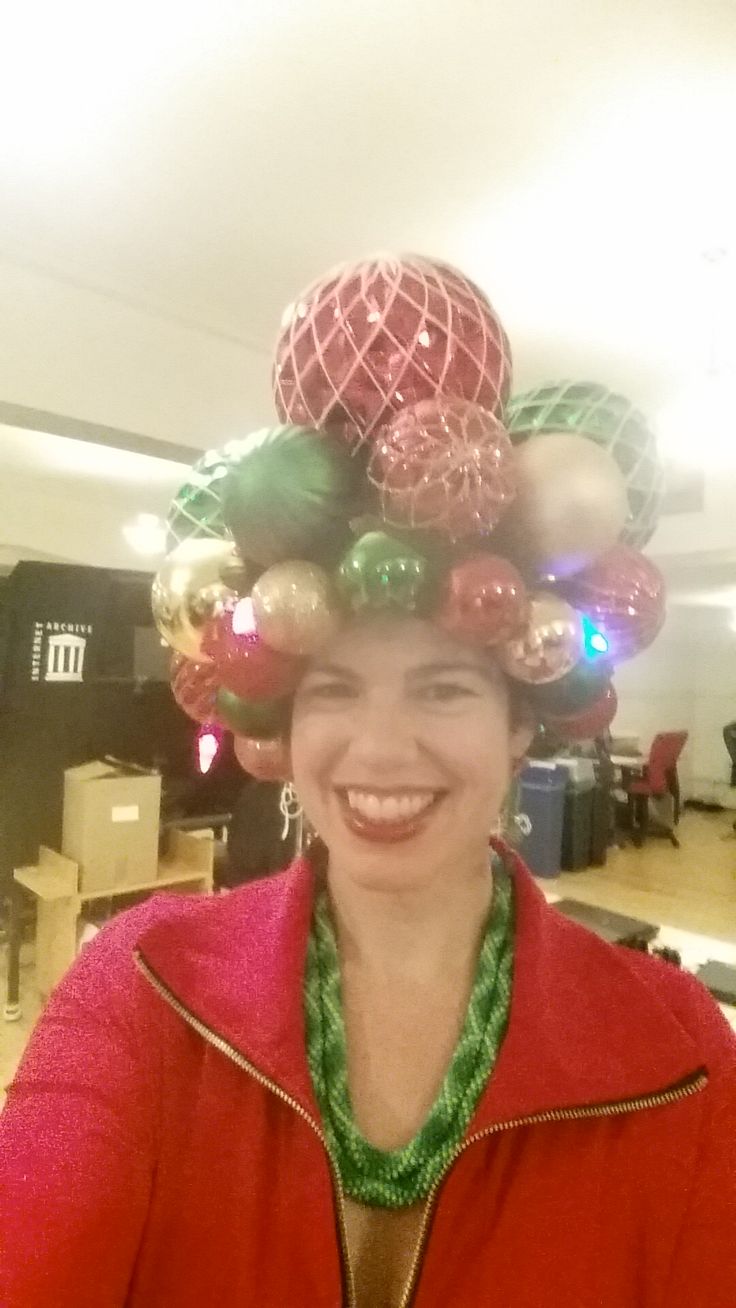 a woman wearing a christmas hat with ornaments on her head