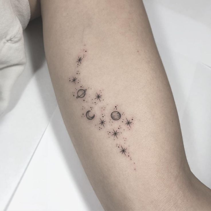 a woman's arm with stars and planets on it