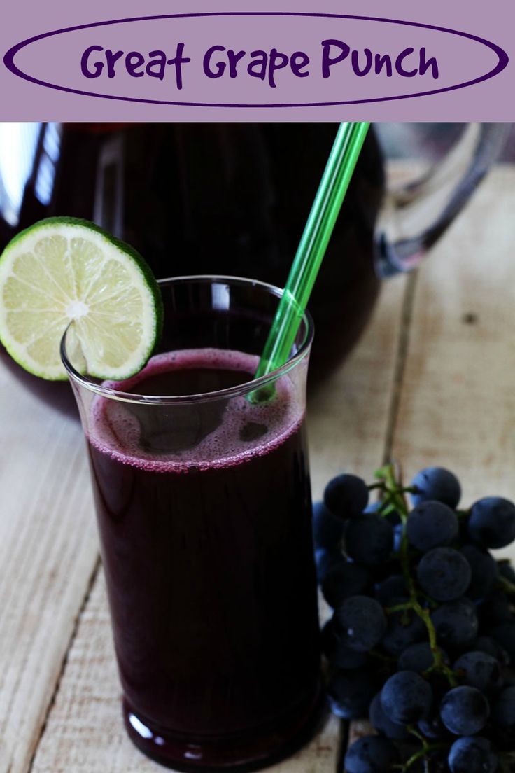 a glass of blueberry lemonade next to some grapes and a pitcher of juice