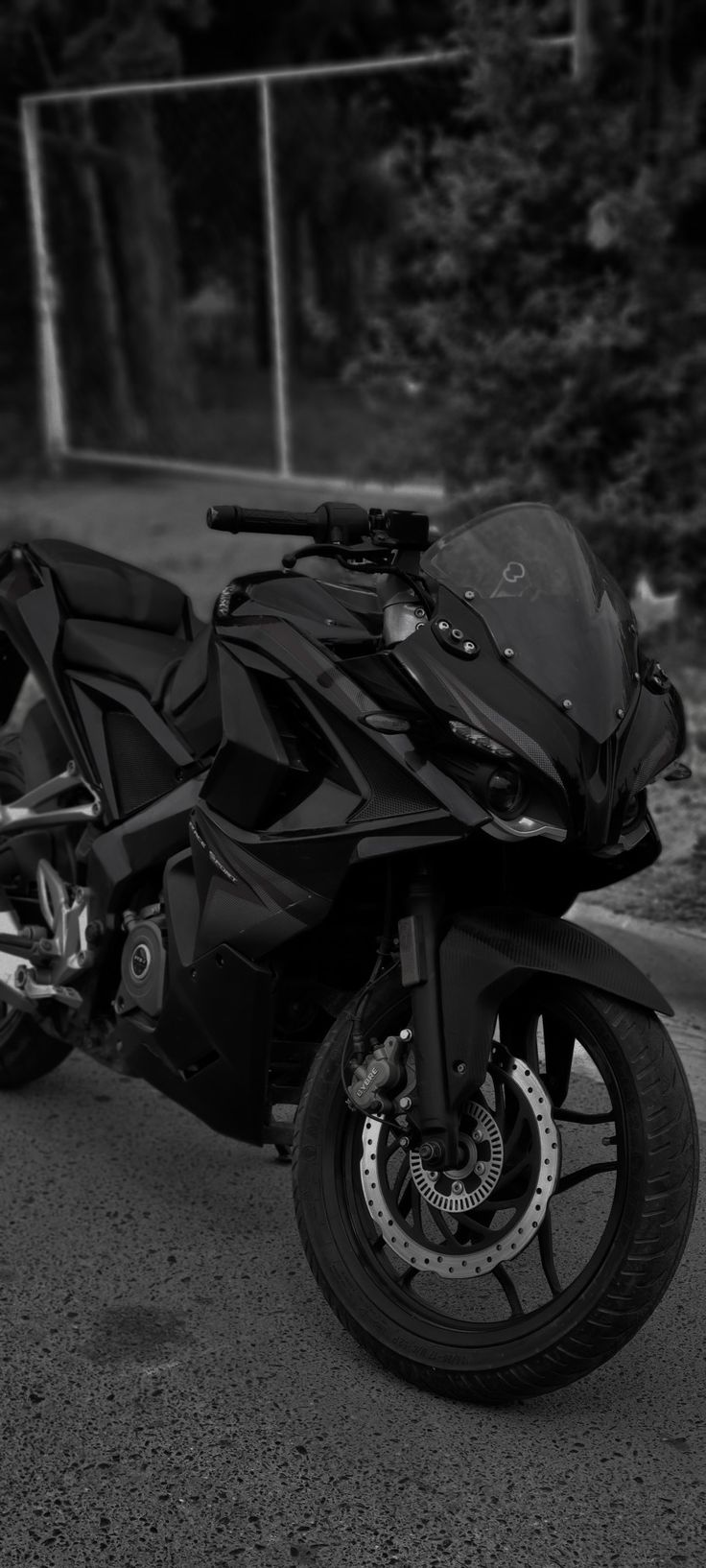 black and white photograph of a motorcycle parked on the street