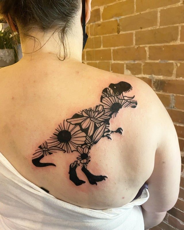 a woman with a dinosaur tattoo on her back