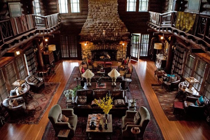 a large living room filled with lots of furniture next to a fire place in a building