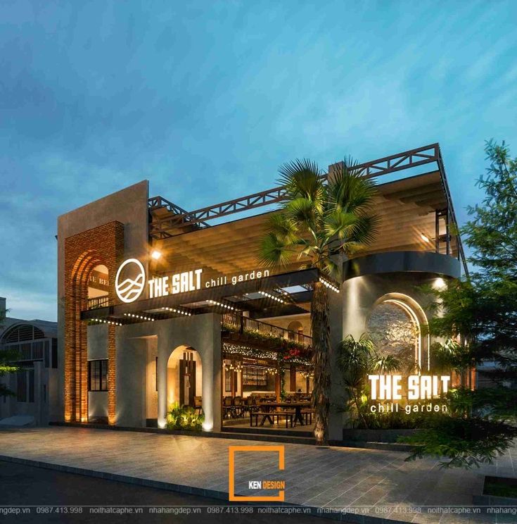 the front entrance to the restaurant, which is lit up with lights and palm trees