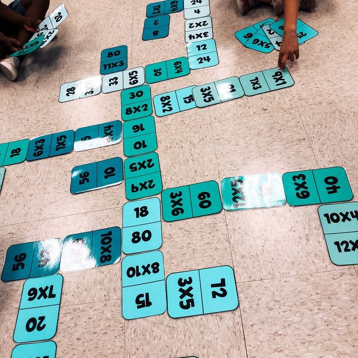 several children are sitting on the floor playing with numbers and signs in front of them