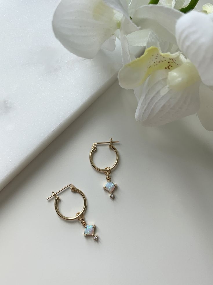 ❤︎ MATERIALS Hoops: 14k Gold Filled Ball Studs and Backing: 14k Gold Filled Charm: Opal / Cubic Zirconia ❤︎ SIZE Hoops: 14mm Ball Studs: 3mm Charm: 6mm x 9mm ❤︎ What is Gold Filled? My 14k Gold Filled hoops and stud earrings are manufactured in the U.S and consists of 5% (1/20) solid gold pressure bonded over brass. They are perfect for those with allergies or sensitive skin. Gold-filled jewelry has 100x more gold alloy than gold plated and because that layer is so much thicker, it means gold-fi Gold Filled Hoops, Buy Earrings, Opal Earrings Stud, Opal Studs, Gold Alloys, Gold Paper, Opal Earrings, Delicate Earrings, Earrings Photo