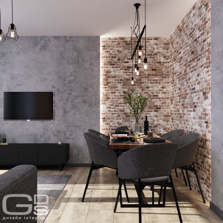 a dining room table and chairs in front of a brick wall with a tv mounted on it