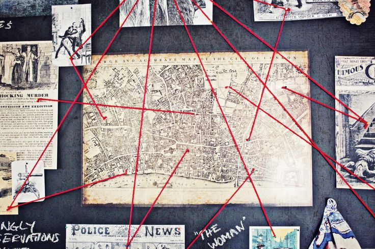 an old map is covered with pins and newspaper clippings on a blackboard