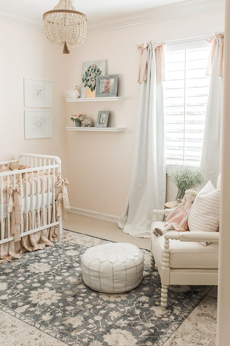 a baby's room with pink walls and white furniture