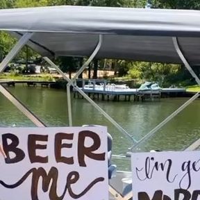 two signs that say beer me and i'm getting married on a boat in the water