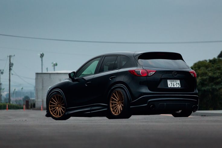 a black car with gold rims parked on the street