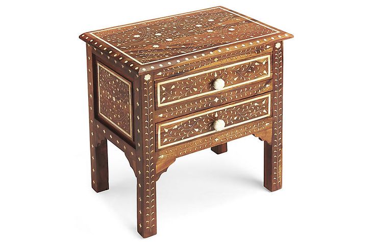 an ornate wooden table with two drawers