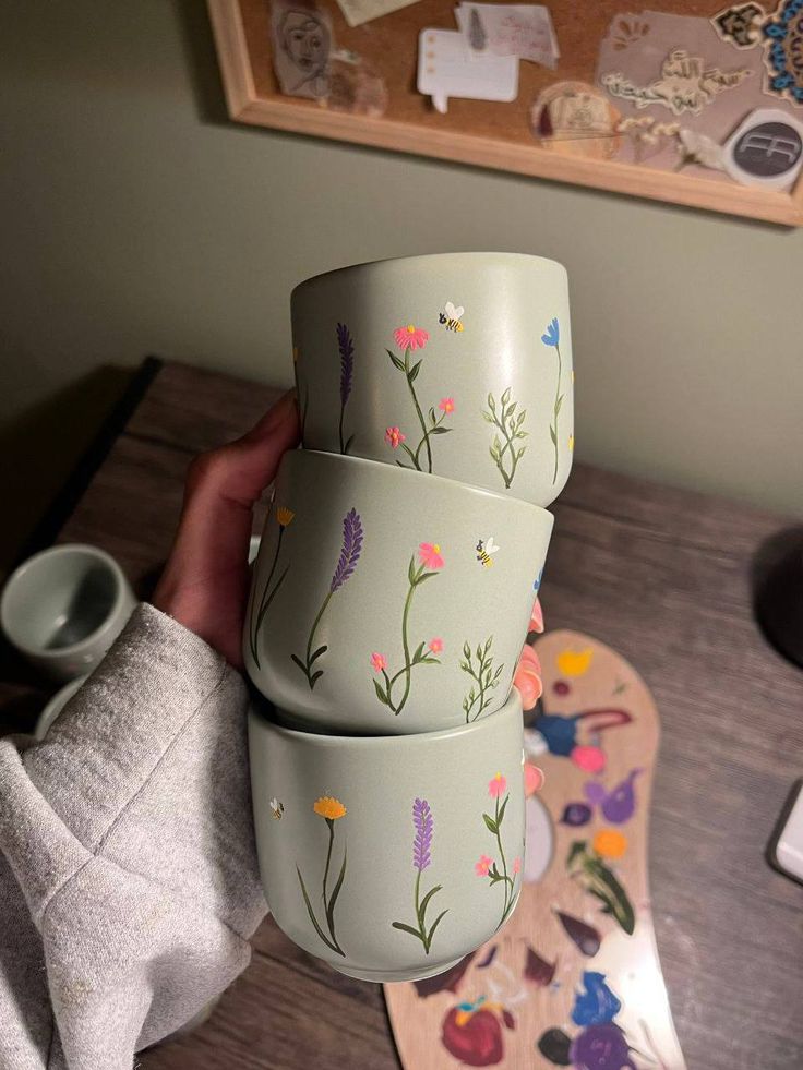 three green cups with flowers painted on them