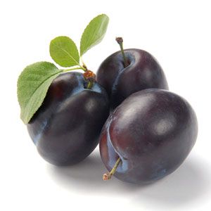 three plums with green leaves on the top and one is dark purple in color