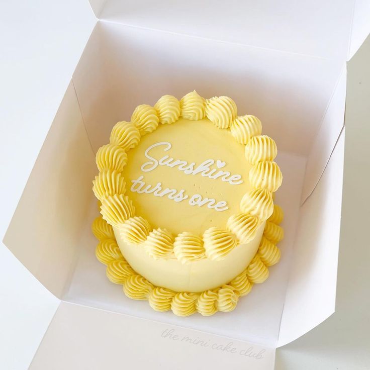 a yellow cake in a white box with the word sunshine on it's side