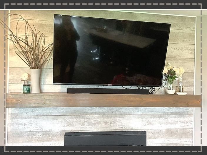 a flat screen tv sitting on top of a wooden mantle