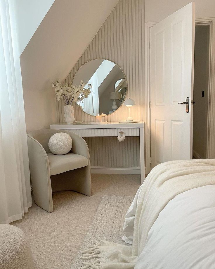 a bedroom with a white bed, vanity and mirror in the corner on the wall