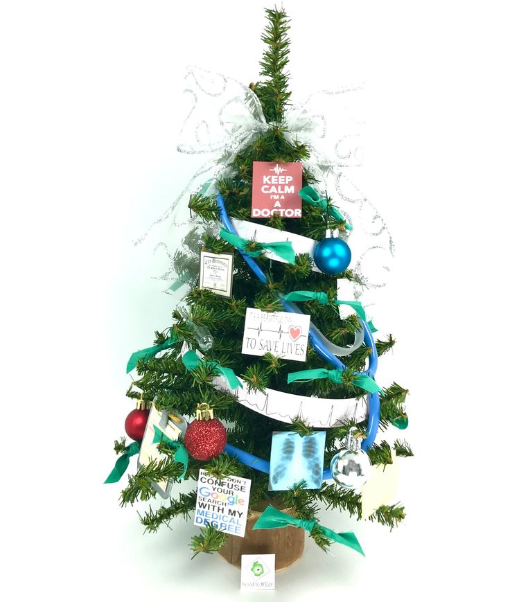 a small christmas tree decorated with ribbons and pictures on it's sides, in front of a white background