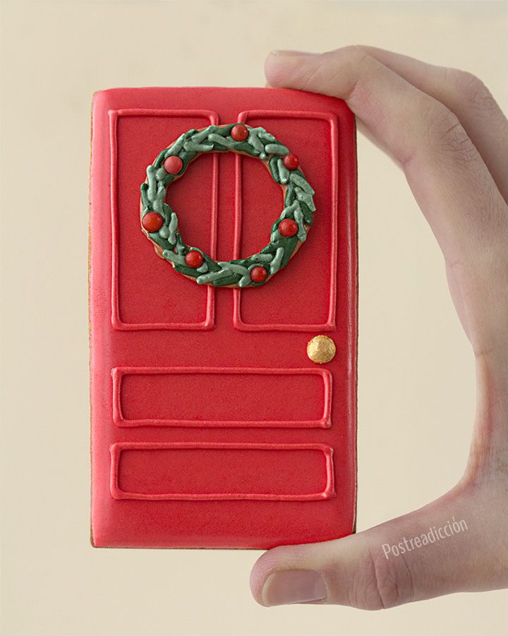 a hand holding up a red phone with a christmas wreath on the front and side