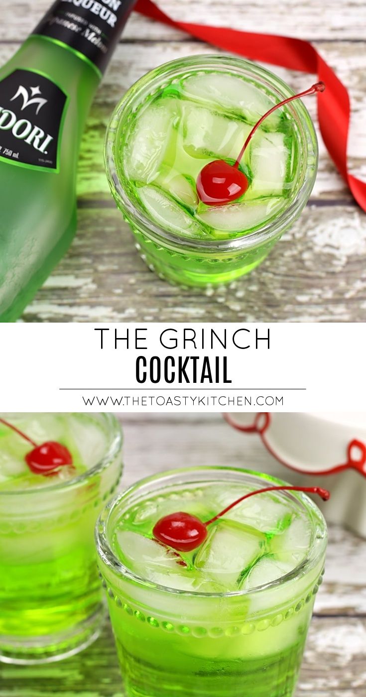 two glasses filled with green liquid and cherries on the rim, next to a bottle of gin