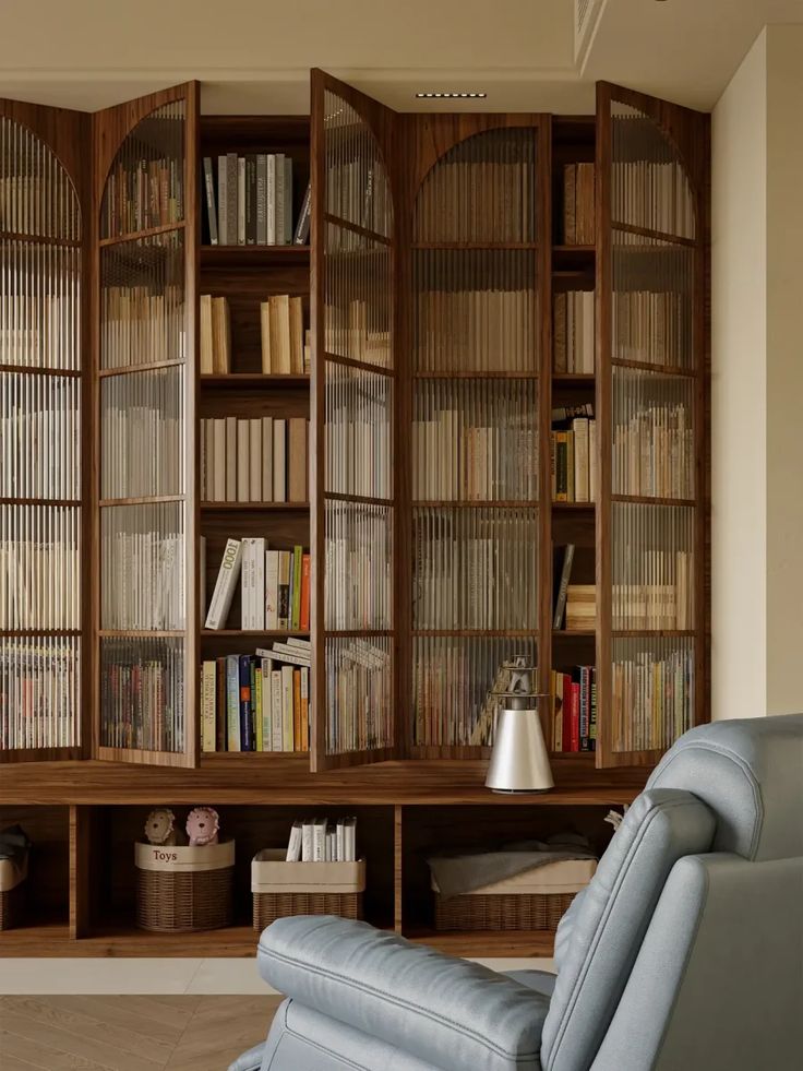 an empty recliner chair in front of a bookcase with many books on it