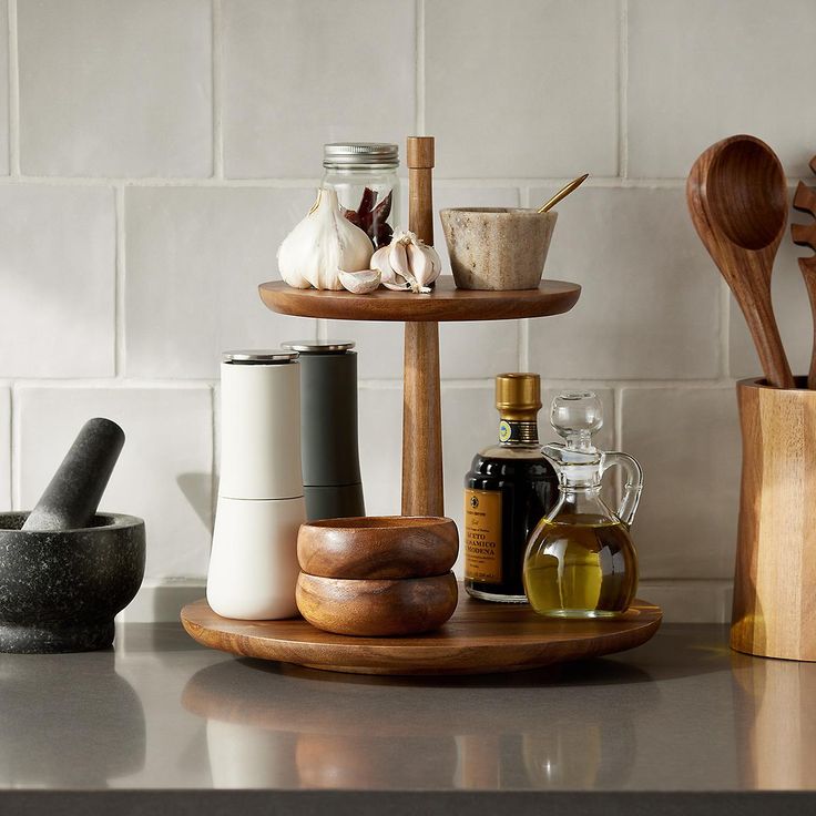 three tiered tray with spices and condiments sitting on top of a kitchen counter