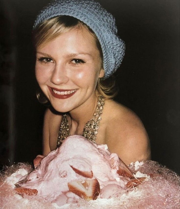 a woman is smiling while holding a large piece of meat in her hands and posing for the camera