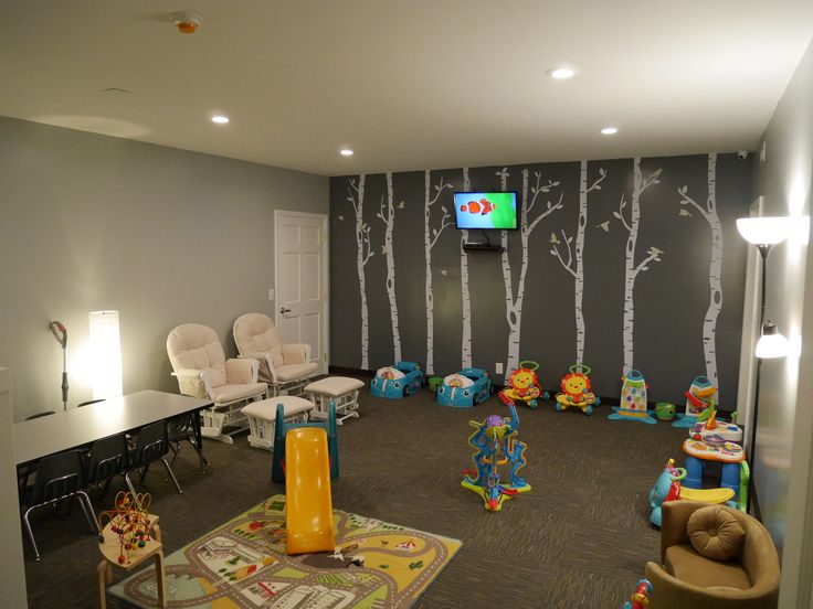 a playroom with chairs, tables and television in the corner for children to play