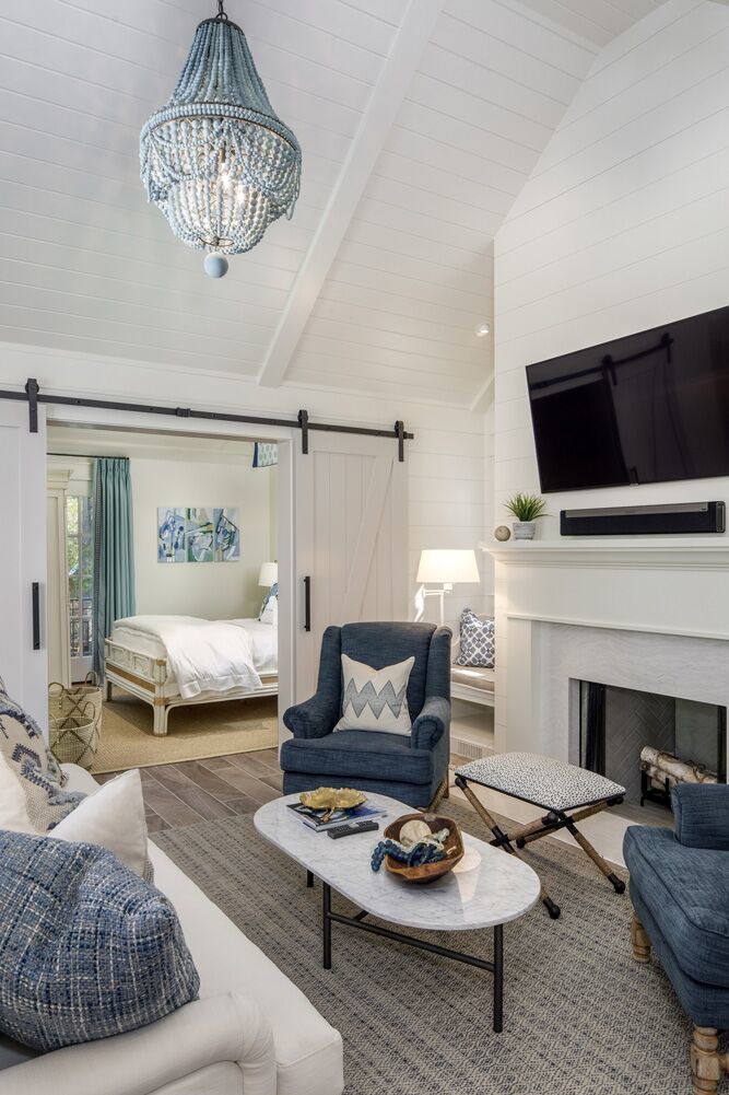 a living room filled with furniture and a flat screen tv mounted on the wall above a fireplace