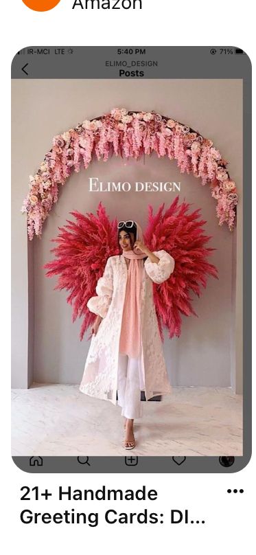 an image of a woman standing in front of a display with pink flowers on it