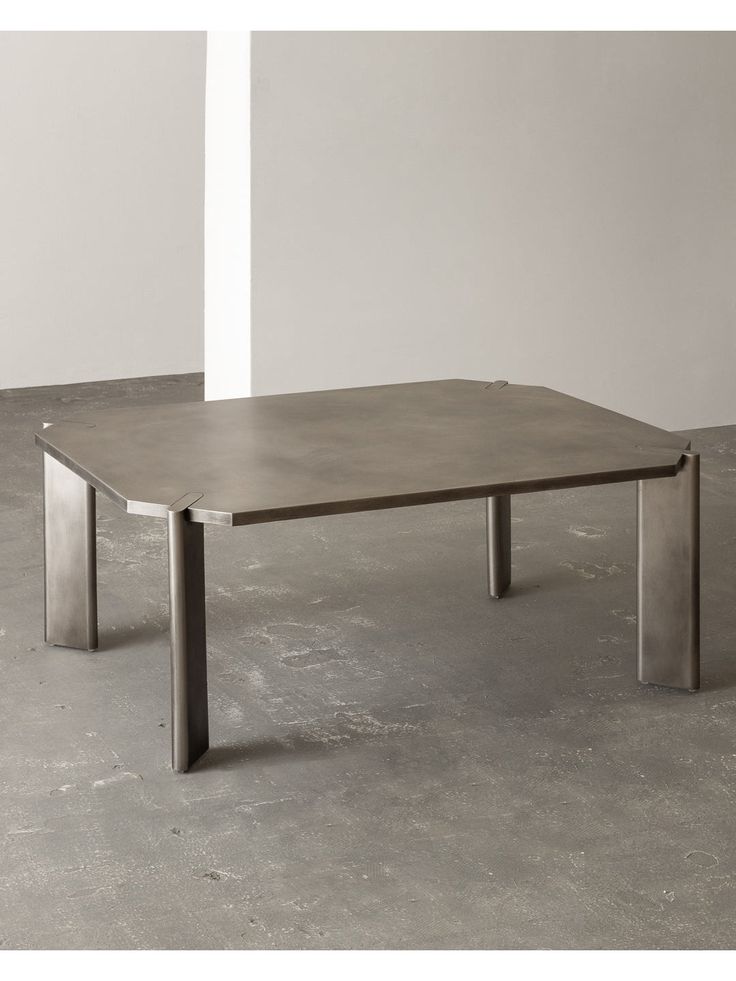 a table that is sitting in the middle of some concrete flooring with one end missing