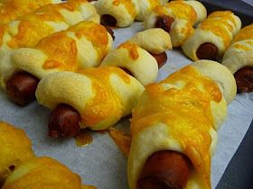 hotdogs wrapped in cheese and mustard are ready to be cooked on the grill