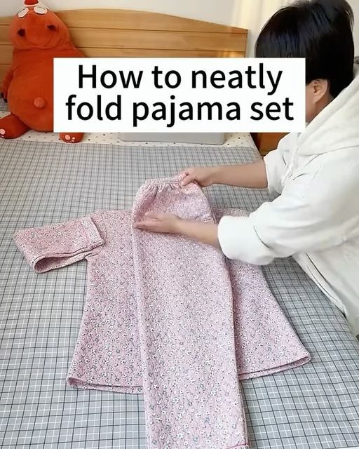 a woman in white shirt laying on bed next to pink pajamas and teddy bear with text overlay reading how to neatty fold pajama set