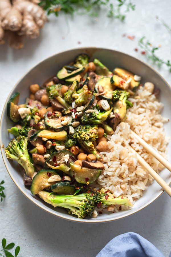 a white bowl filled with rice, broccoli and chickpea stir fry