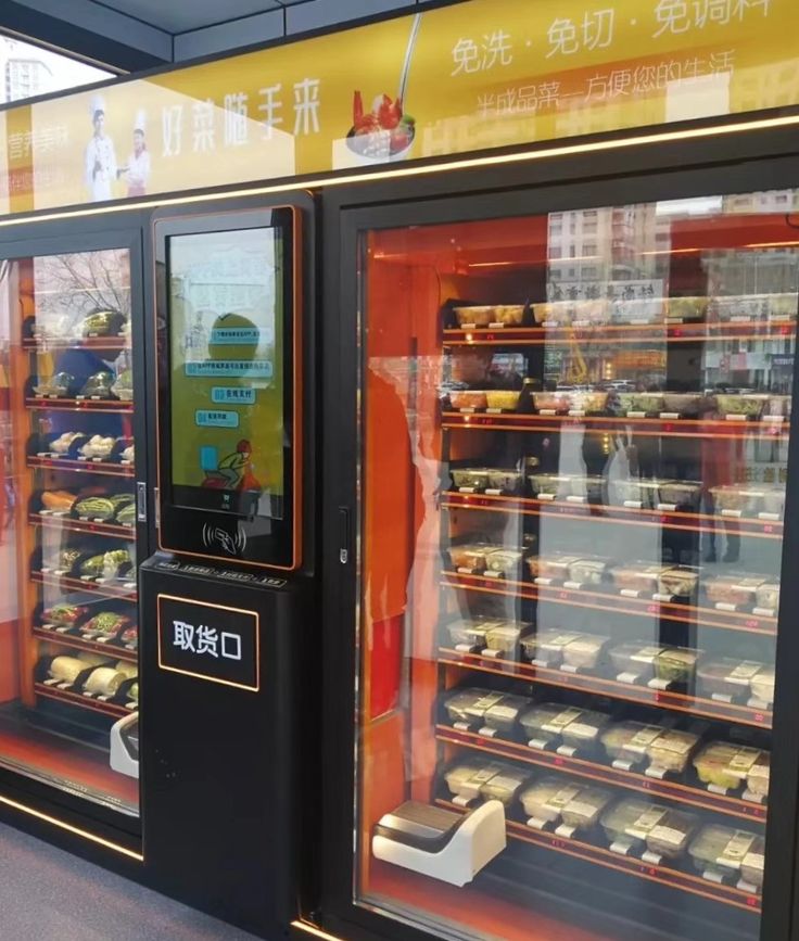 two vending machines in front of a display case filled with cakes and pastries