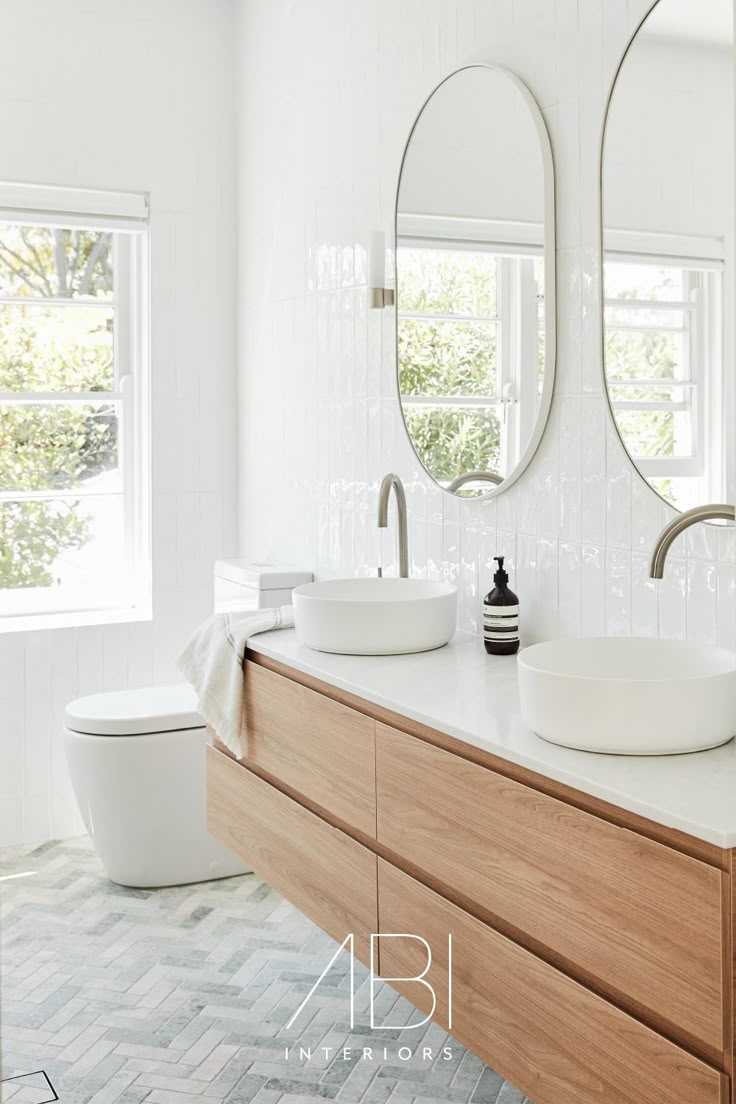 a bathroom with two round mirrors above the sinks