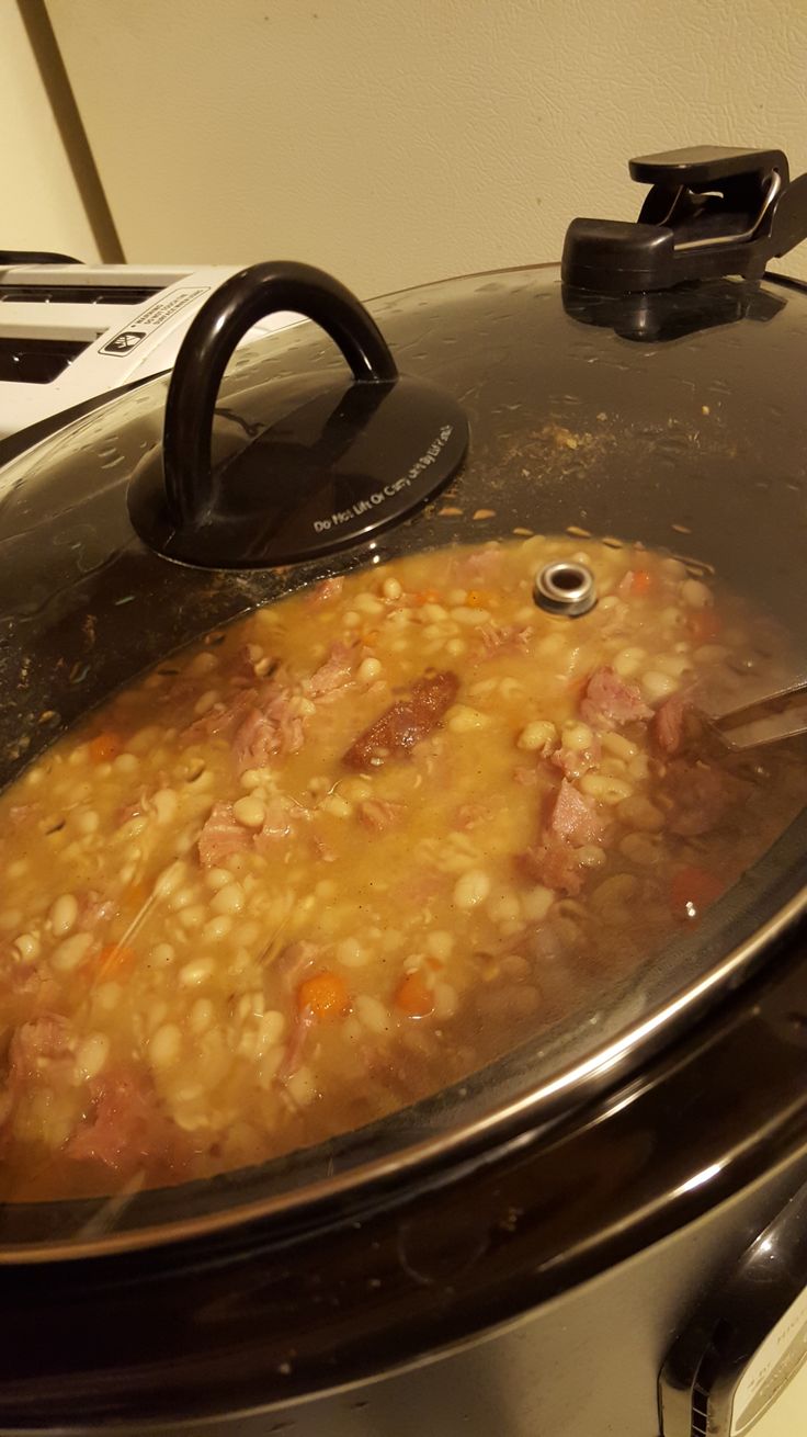 a slow cooker filled with food sitting on top of a stove