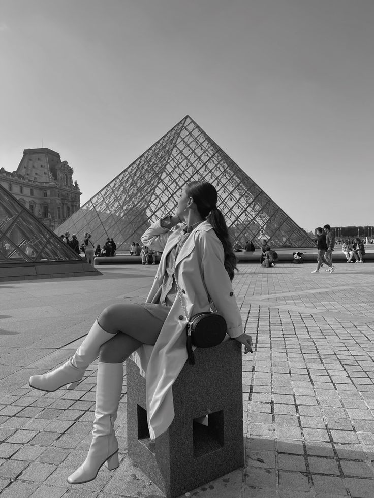 a woman sitting on a bench in front of the pyramid