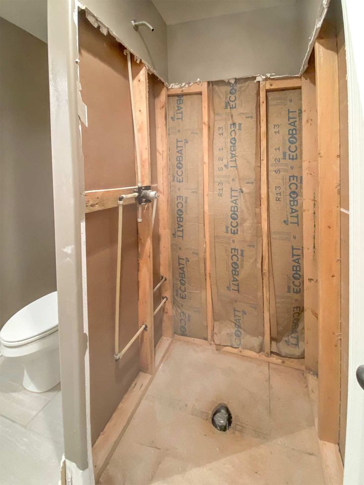 an unfinished bathroom with the toilet in it's stall and walls being built up