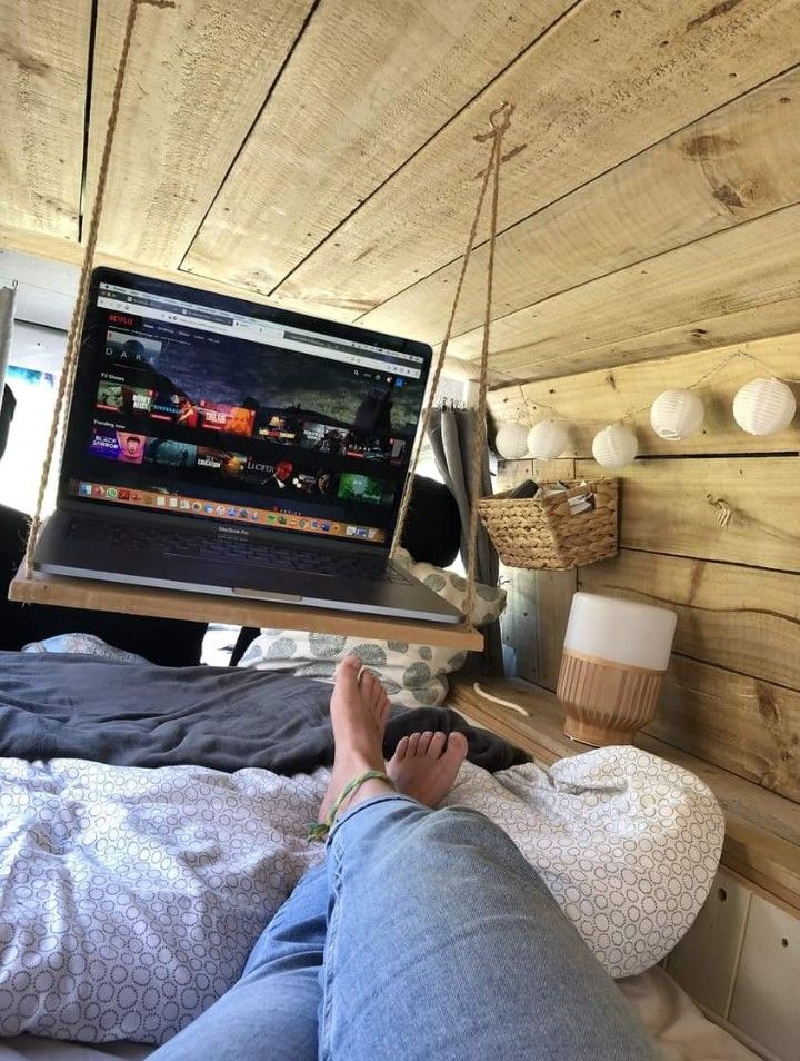 a person laying in bed with their feet up on the edge of a laptop computer