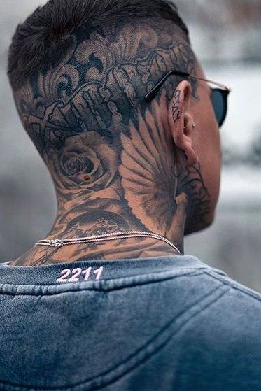 the back of a man's head with tattoos on his neck and shoulder,