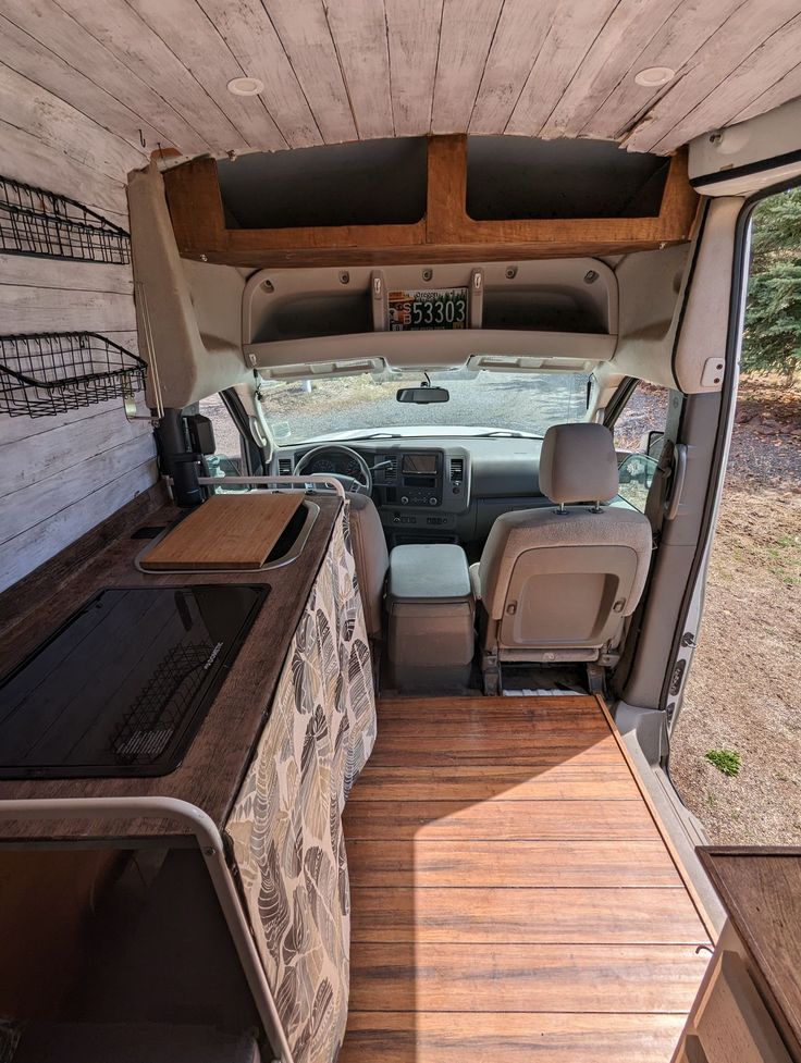 the interior of an rv with wood flooring and storage area for camper vans