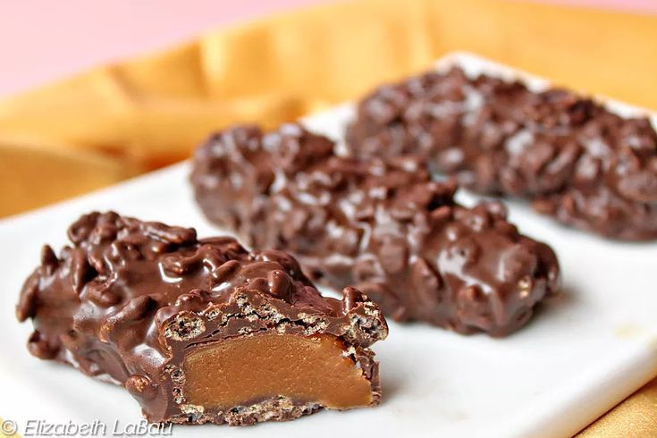 three pieces of chocolate covered cookies on a white plate