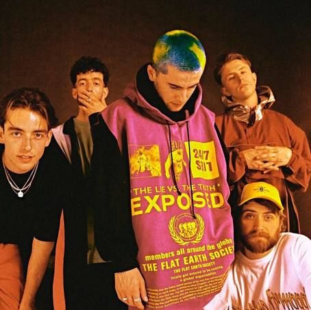 a group of young men standing next to each other in front of a sign that says exposed