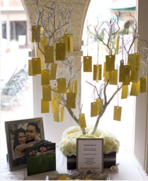 there is a tree with yellow notes attached to it and some pictures on the window sill