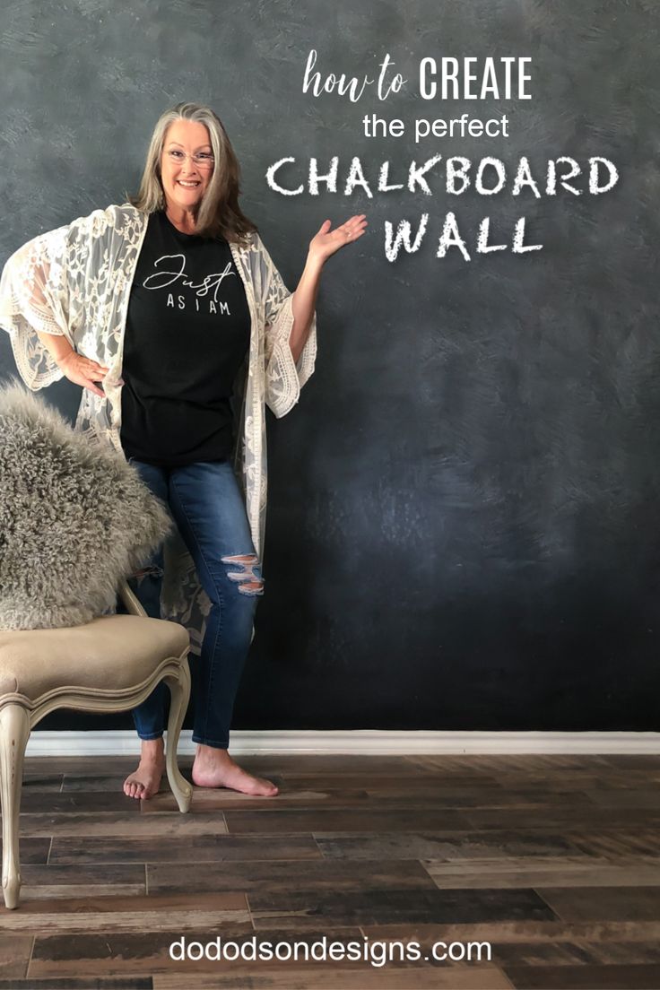 a woman standing in front of a chalkboard wall