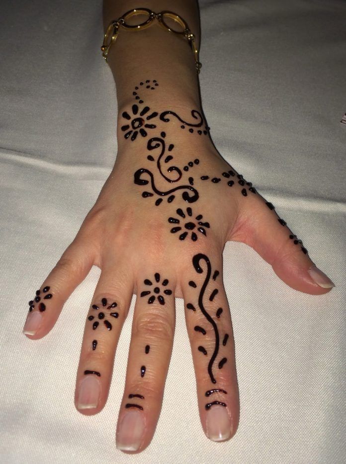 a woman's hand with henna tattoos on it