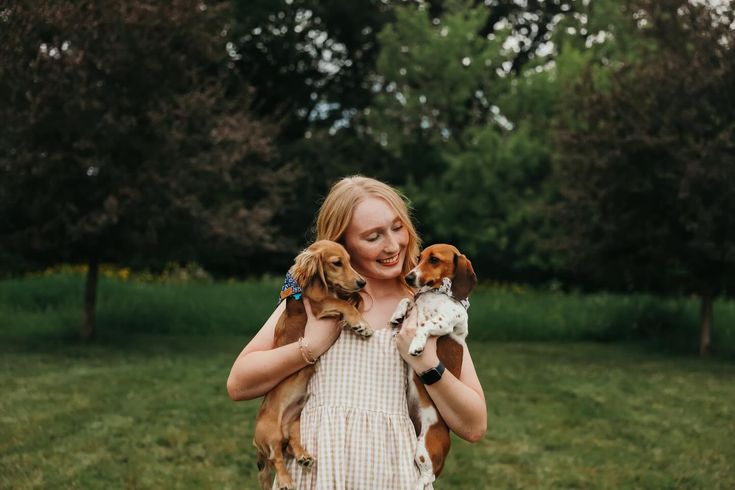 a woman holding two dogs in her arms