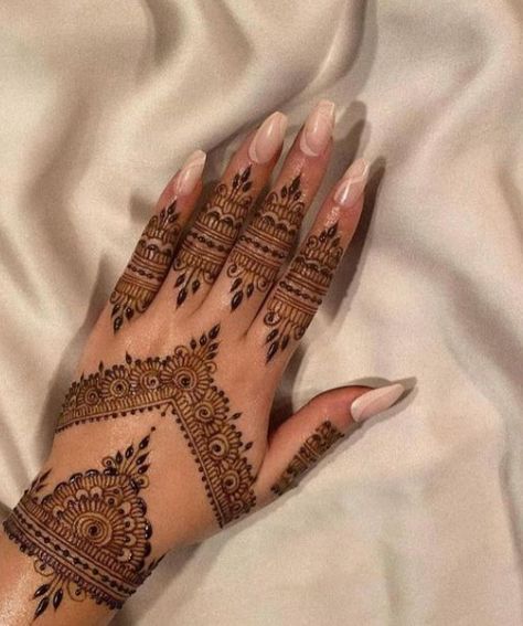 a woman's hand with henna tattoos on it