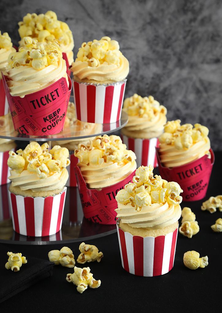 several red and white striped cupcakes with popcorn on top